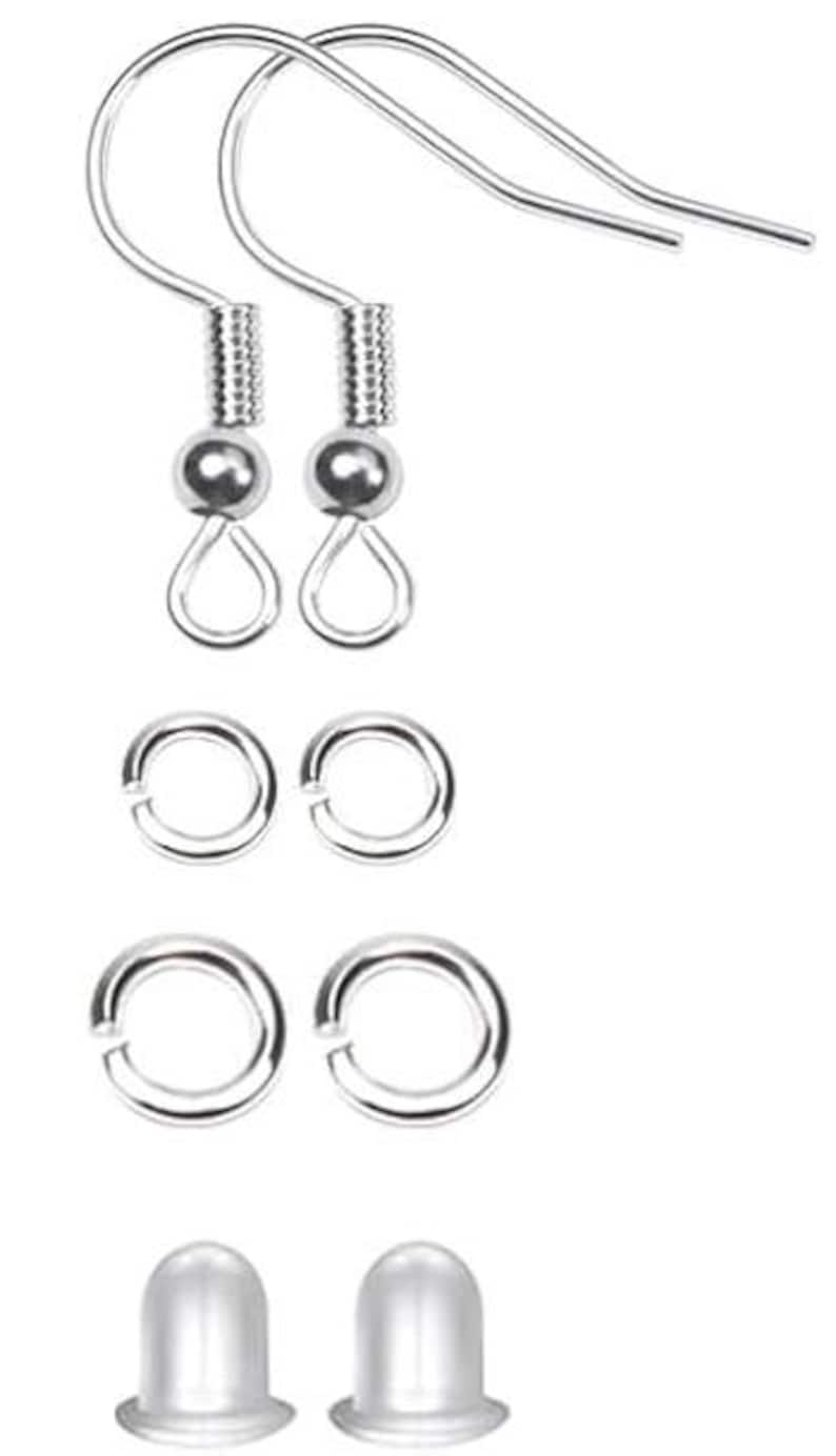 Puede incluir: Un conjunto de componentes de pendientes plateados, que incluye dos ganchos para pendientes, dos peque&ntilde;os anillos de salto, dos anillos de salto m&aacute;s grandes y dos topes transparentes para pendientes. Los componentes est&aacute;n dispuestos sobre un fondo blanco.