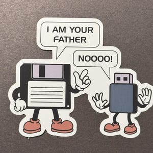 May include: A white sticker with a cartoon floppy disk and a USB drive. The floppy disk is saying "I am your father" and the USB drive is saying "Noooo!"
