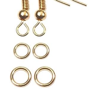 Puede incluir: Un conjunto de componentes de pendientes dorados, que incluyen dos ganchos para pendientes, dos peque&ntilde;as cuentas redondas, dos anillas, dos anillas m&aacute;s grandes y dos topes transparentes. Los componentes est&aacute;n dispuestos sobre un fondo blanco.
