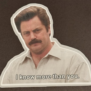 May include: A sticker featuring a man with a mustache and a serious expression. The text "I know more than you." is printed below the image.