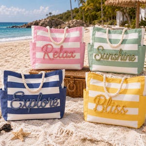 Könnte beinhalten: Vier rechteckige Tragetaschen aus Segeltuch mit horizontalen Streifen in Pink, Grün, Blau und Gelb. Jede Tasche hat weiße Seilgriffe, Seitentaschen und ein in Schreibschrift appliziertes Wort auf der Vorderseite: Relax, Sunshine, Explore, Bliss.