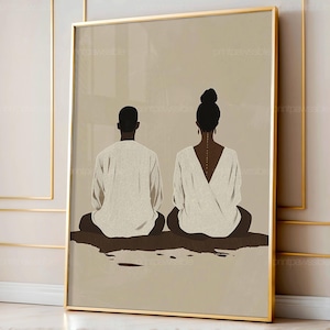 Puede incluir: Impresión artística enmarcada que muestra dos figuras sentadas, vistas desde atrás, en un estilo minimalista. Las figuras, vestidas de blanco, se destacan sobre un fondo beige, enmarcadas en dorado. La obra evoca serenidad.