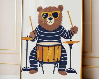 May include: A framed art print featuring a cartoon bear playing a drum set. The bear wears sunglasses and a blue and white striped shirt. The drum set is yellow and the drumsticks are tan. The artwork is framed in a gold frame.