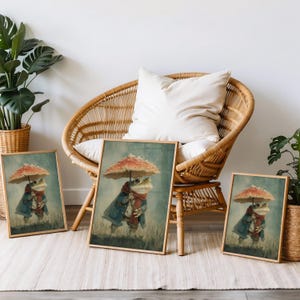 May include: Three framed art prints featuring a whimsical frog character. The frog is depicted wearing a blue coat, red scarf, and holding a mushroom umbrella. The artwork has a vintage, storybook aesthetic, with a muted color palette.