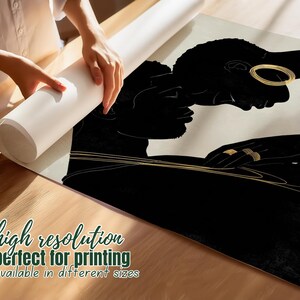 May include: A black and gold art print featuring two silhouetted figures in an embrace. The print has gold jewelry accents and is being unrolled. Text on the print reads "high resolution" and "available in different sizes".