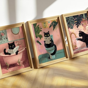 May include: Three framed illustrations of black cats in a bathroom setting. The first image shows a cat taking a bath and reading a newspaper. The second image shows a cat sitting on a toilet and reading a newspaper. The third image shows a cat washing its paws in a sink.