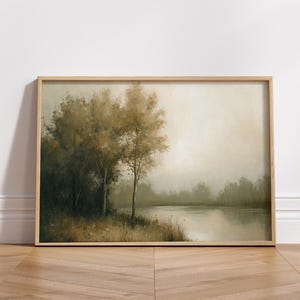 May include: A framed painting of a misty landscape with two trees in the foreground and a lake in the background. The colors are muted greens and browns.