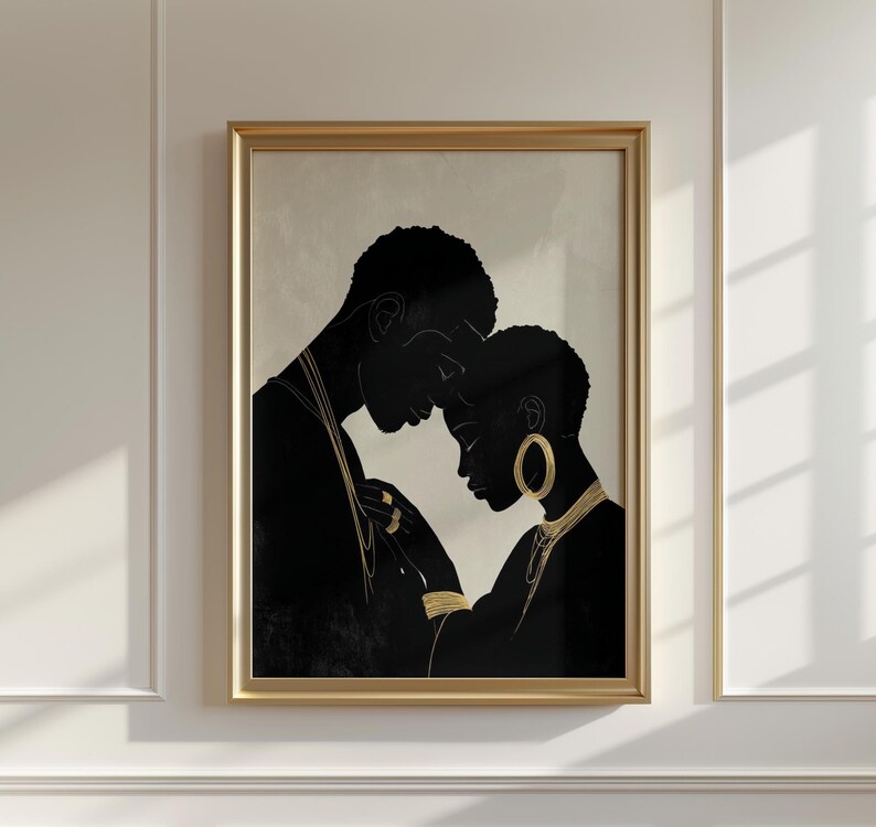 May include: A framed art print featuring a black and gold illustration of two figures in an embrace. The figures are in silhouette, with gold jewelry accents. The artwork is set against a neutral background, and framed in a gold tone.