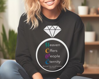May include: Black sweatshirt featuring a white diamond ring graphic and the text "Heaven Offers People Eternity" in colourful letters. The text is inside a white ring. The quote "Because I live, you will live also." is below the ring graphic. The quote is attributed to John 14:19.