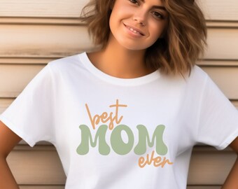 May include: White t-shirt with the text "best MOM ever" in green and orange lettering.