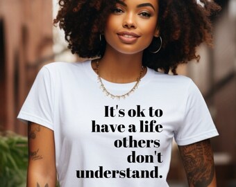 May include: A white t-shirt with the text "It's ok to have a life others don't understand."