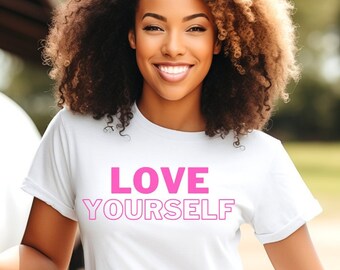 May include: A woman wearing a white t-shirt with the text "LOVE YOURSELF" printed in pink. She is standing in front of a wooden fence and a white horse.