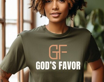 May include: A woman wearing a green t-shirt with the text "GF GOD'S FAVOR" in white letters and a brown logo.