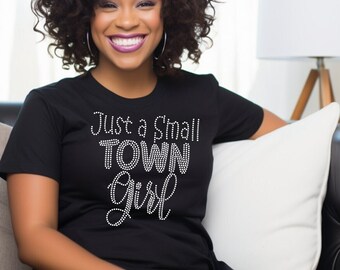 May include: A black t-shirt with the text "Just a Small Town Girl" in white rhinestones.