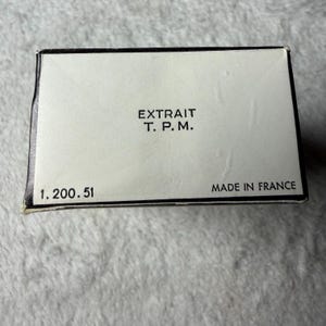 May include: A rectangular white box with a black border. The text "EXTRAIT T. P. M." is printed in black in the center. The number "1. 200. 51" is printed in the bottom left corner, and "MADE IN FRANCE" is printed in the bottom right corner.