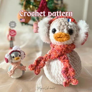 Könnte beinhalten: Häkelanleitung mit zwei Pinguin-Plüschtieren. Der größere Pinguin hat einen weißen Körper, einen grauen Kopf, einen orangefarbenen Schnabel und einen rot-orangen Schal. Der kleinere Pinguin hat ein ähnliches Design. Der Text "Crochet pattern" steht oben.