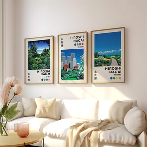 May include: Three framed prints of cityscapes and landscapes by artist Hiroshi Nagai. The prints feature a tropical scene, a city skyline, and a mountain road. Each print has the artist's name and the title of the artwork in Japanese and English.