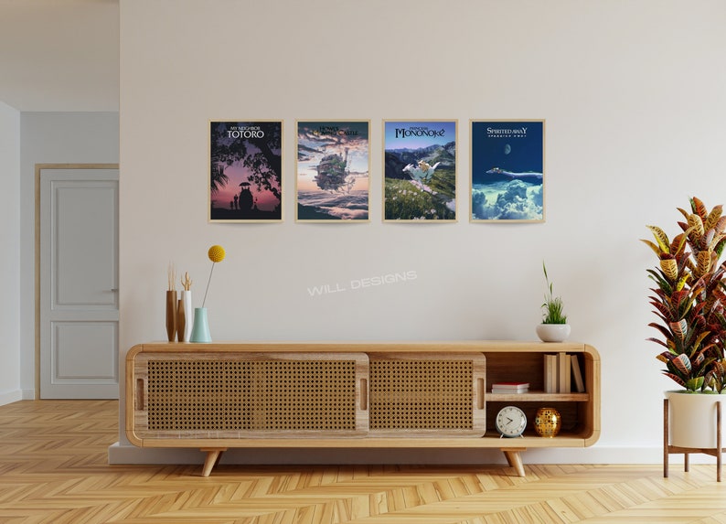 May include: Four framed art prints with movie-themed illustrations hang on a white wall. The prints feature colorful scenes with text. A wooden cabinet with a woven front and decorative items sits below the artwork. The room has a warm, inviting atmosphere.