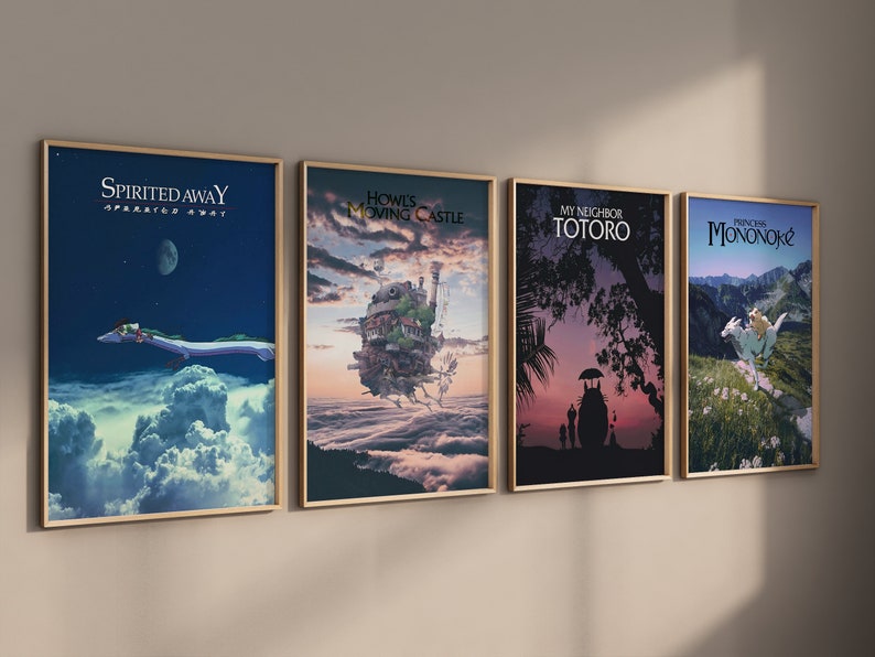May include: Four framed art prints featuring animated movie posters. The posters include "Spirited Away," "Howl's Moving Castle," "My Neighbor Totoro," and "Princess Mononoke." Each poster has a gold-colored frame and is displayed against a neutral wall.