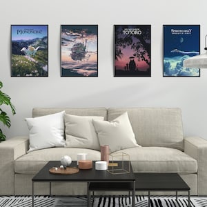 May include: Four framed movie posters hang above a beige sofa. The posters feature artwork from animated films, including "Princess Mononoke," "Howl's Moving Castle," "My Neighbor Totoro," and "Spirited Away."