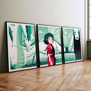 May include: Three framed prints of a Japanese animated film. The first print features a white dragon with green and blue accents. The second print features a young girl with red hair and a red and white outfit. The third print features a black and white figure with a white mask. The text "千と千尋の神隠し" is visible on the third print.