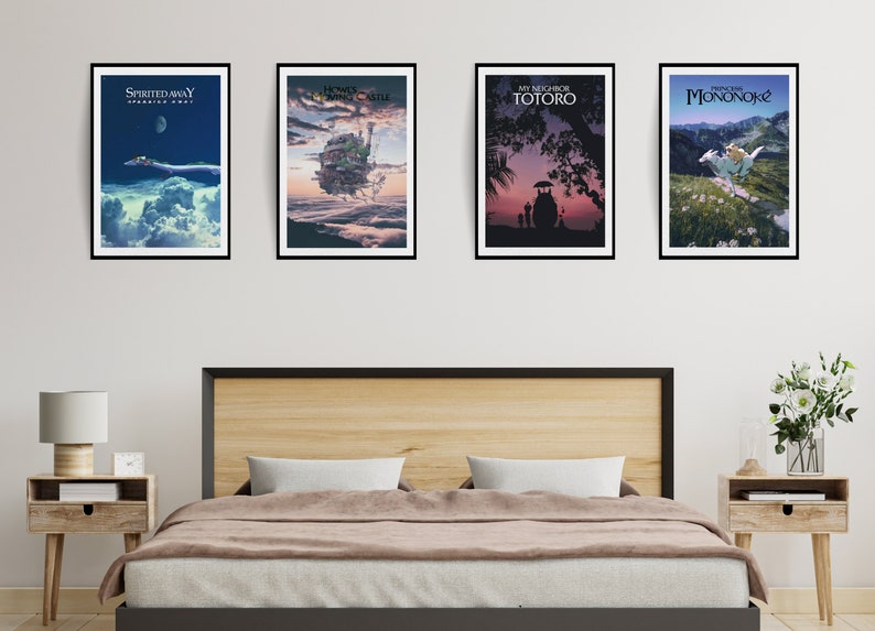 May include: Four framed movie posters featuring Japanese animated films. The posters are displayed above a bed with a wooden headboard. The posters include "Spirited Away," "Howl's Moving Castle," "My Neighbor Totoro," and "Princess Mononoke."