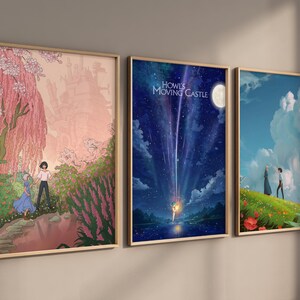 May include: Three framed prints of scenes from the animated film Howl's Moving Castle. The first print shows a pink and white tree with a couple standing in front of it. The second print shows a blue sky with a shooting star and the text "Howl's Moving Castle". The third print shows a couple standing on a green hill with a blue sky and white clouds in the background.