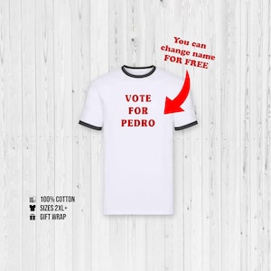 Op de afbeelding: Wit ringer t-shirt met zwarte boorden, met de rode tekst "VOTE FOR PEDRO". Het shirt bevat ook de tekst "You can change name FOR FREE" en is gemaakt van 100% katoen. Maten 2XL+ beschikbaar.