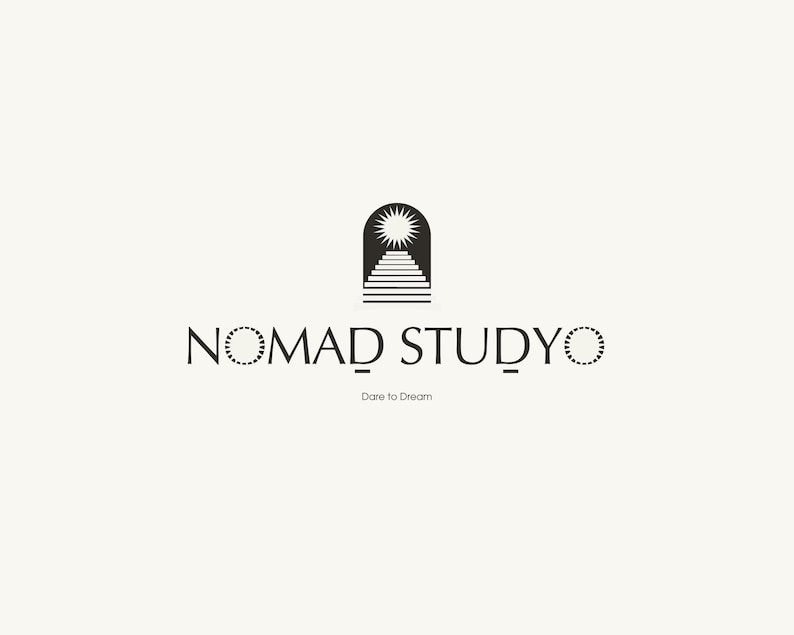 Puede incluir: Dise&ntilde;o de logotipo minimalista con el texto "NOMAD STUDYO" en fuente serif, con un icono estilizado de sol y escalera encima. El lema "Dare to Dream" est&aacute; debajo del texto, todo en negro sobre un fondo crema.