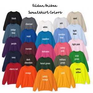 May include: A selection of Gildan Unisex sweatshirts in a variety of colours, such as black, white, and navy. The image showcases a spectrum of shades, from light pink to forest green, with the colour names printed above each sweatshirt. The text "Sweatshirt Colors" is at the top.