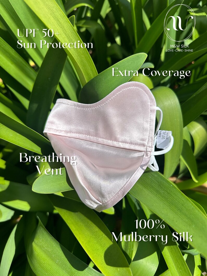May include: A light pink silk face mask with a breathing vent and UPF 50+ sun protection. The mask is made of 100% mulberry silk and has extra coverage. The text "M&W SILK LOVE-CARE-SHINE" is printed on the mask.