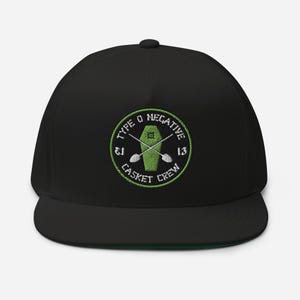May include: Black flat-brimmed baseball cap with a green underbill. The cap features a circular embroidered patch with the text "TYPE O NEGATIVE" and "CASKET CREW" around a coffin and crossed oars.