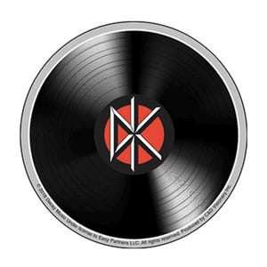 May include: A black vinyl record with a white and red logo in the center. The logo features a stylized "NK" design within a red circle. The record has a silver outer ring and the text "© 2018 Decay Music Under license to Easy Partners LLC. All rights reserved. Produced by C&D Visionary Inc."