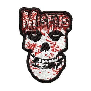Peut inclure: Crâne brodé noir et blanc avec le mot "Misfits" en rouge avec du sang qui coule au-dessus.