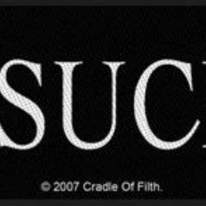 May include: Black rectangular patch with the white text "I SUCK" and a pentagram above the letter "i". The text "© 2007 Cradle Of Filth" is at the bottom. The patch is likely for clothing or accessories.