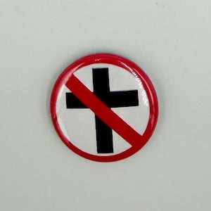 Op de afbeelding: Een ronde pinback-button met een witte achtergrond en een dik zwart kruis in het midden. Het ontwerp is omgeven door een dikke rode cirkelvormige rand, met een diagonale rode streep die van linksboven naar rechtsonder over het kruis loopt.