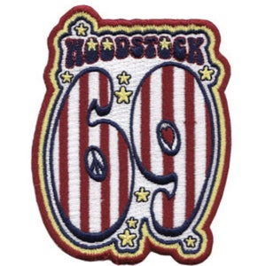 Può includere: Una toppa a strisce rosso, bianco e blu con il testo "Woodstock 69" in un font retrò. La toppa è circondata da un contorno giallo e ha stelle intorno ai bordi.