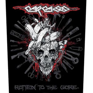 May include: Black rectangular patch with a white skull and heart design, surrounded by tools. The red text at the top reads "CARCASS", and "ROTTEN TO THE GORE" is at the bottom. A graphic illustration.