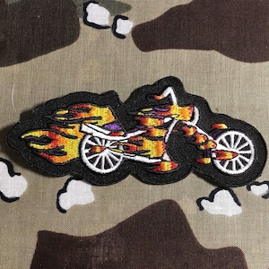 May include: A black and yellow embroidered patch of a motorcycle with flames on a black background.