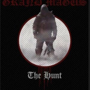 May include: A black and white image of a hooded figure standing in a circle with a red border. The text "GRAND MAGUS" is at the top of the image and "The Hunt" is at the bottom.