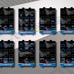 May include: A collection of eight black game console overlays, each with a unique game title and button layout. Titles include "BALLBLAZER," "BASEBALL," "BERZERK," "CENTIPEDE," "COUNTERMEASURE," "DEFENDER," "DIG DUG," and "FOOTBALL." Each overlay has a blue, yellow, and red stripe at the bottom.