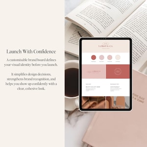 May include: A tablet displays a brand board design with the text "Lelland & Co." and color swatches in shades of red and pink. The tablet is surrounded by an open book, a cup of coffee, and a notebook with the text "ONE DAY AT A TIME."