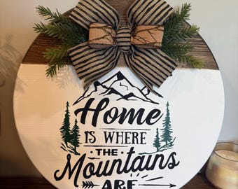 Home is where the mountains are wooden round sign