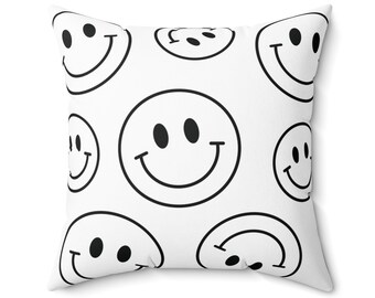 May include: White throw pillow with a black and white smiley face pattern.