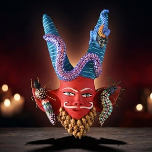 May include: A red-faced mask with a white mustache and a beard made of small skulls. The mask features two tall blue horns wrapped in purple octopus tentacles, with a black spider on the left ear and a multi-colored centipede on the right ear.