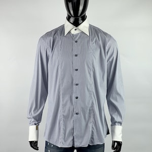 May include: A long-sleeved, striped dress shirt with a white collar and cuffs. The shirt has a button-down collar and a button-up front.