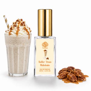 May include: A glass of milkshake topped with whipped cream, caramel drizzle, and pecans, alongside a rectangular perfume bottle with a gold cap. The label reads Scentsies Butter Pecan Milkshake EAU DE PARFUM 30 ML | 1.0 FL OZ, with a pile of pecans and caramel nearby.