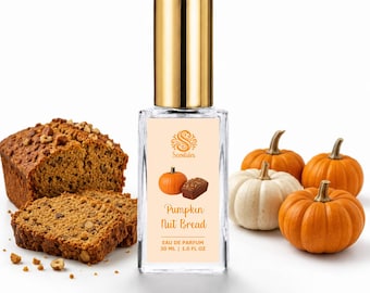 May include: A rectangular glass perfume bottle with a gold cap and a label reading Scentsies Pumpkin Nut Bread Eau de Parfum 30 ml | 1.0 fl oz. The label features a pumpkin and a loaf of nut bread. The bottle is surrounded by nut bread and pumpkins.