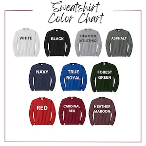 May include: A color chart for sweatshirts, featuring various colors including white, black, heather athletic, asphalt, navy, true royal, forest green, red, cardinal red, and heather maroon. Each color is displayed on a crewneck sweatshirt.