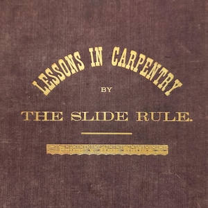 May include: A brown book with gold lettering on the cover. The title is "Lessons in Carpentry by The Slide Rule."